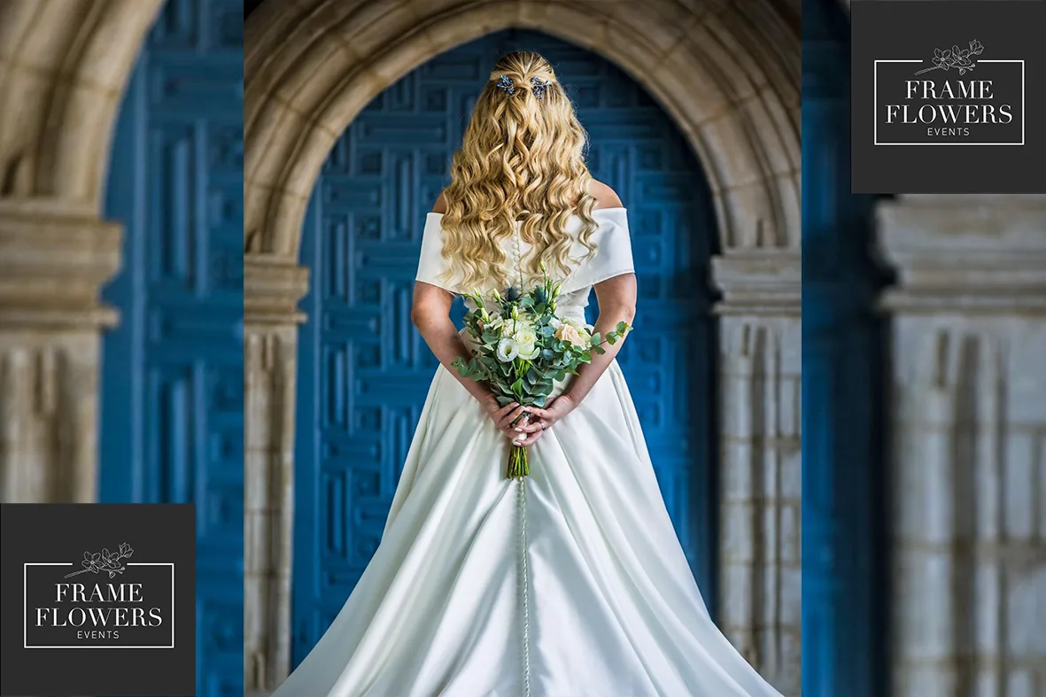 Bride holding her bouquet in front of the blue door of a church in Cyprus