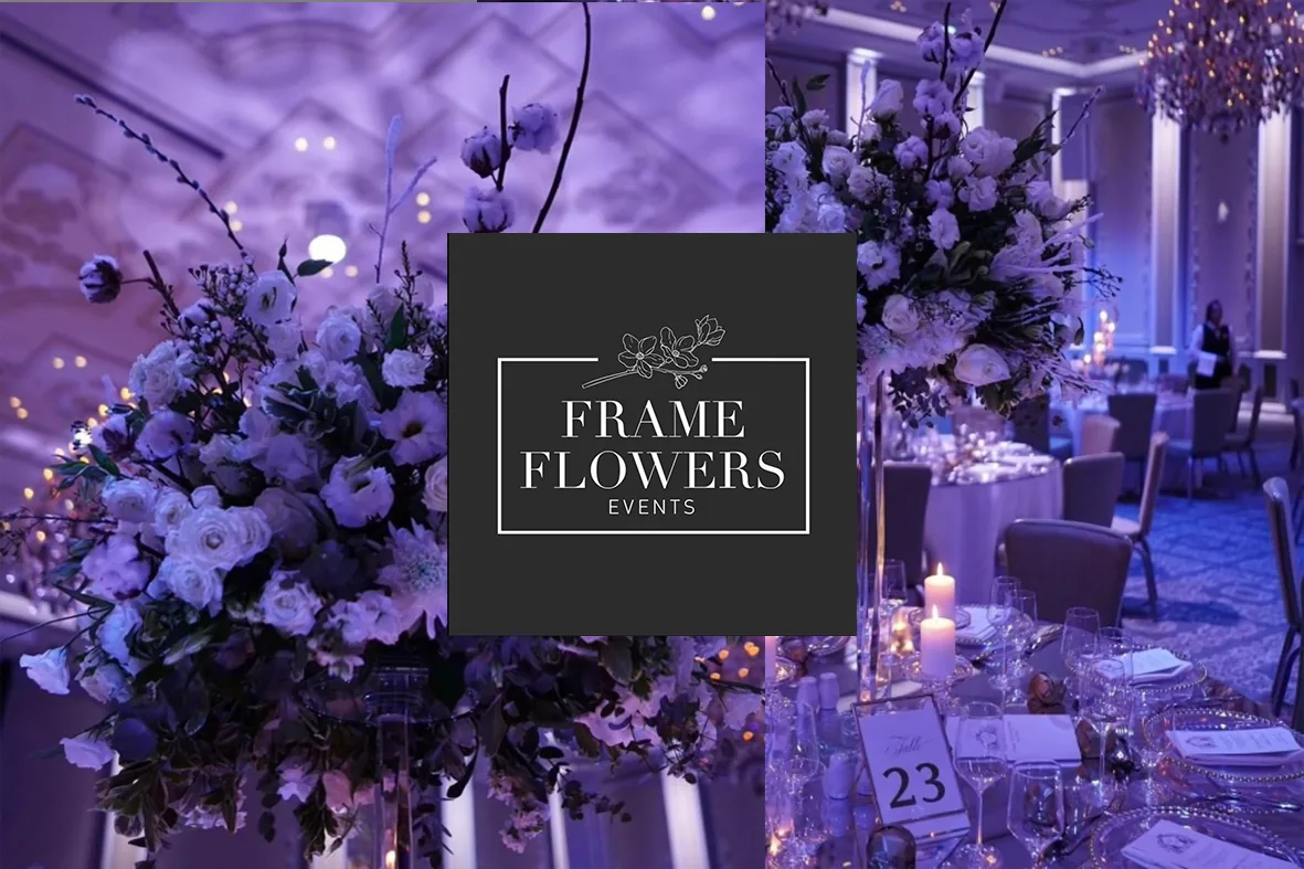 Ballroom with tall white floral arrangements in purple light