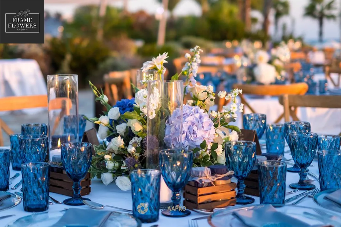 Evening wedding table with blue glassware and candles by the sea near Paphos